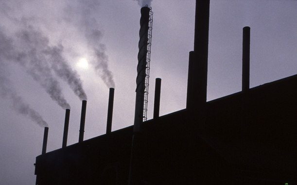 A sillouitte of a power plant against a purple sky